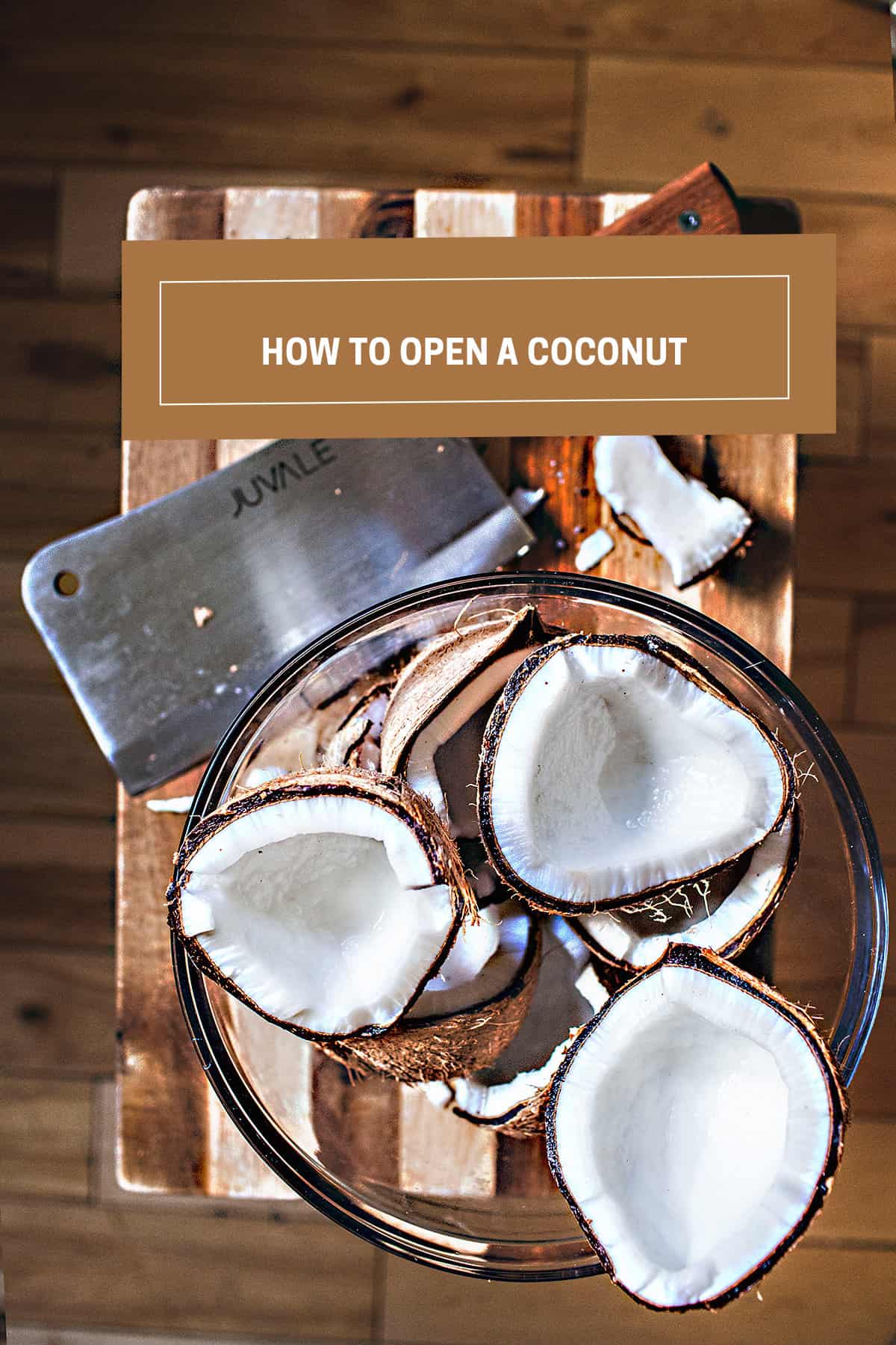 cracked coconuts in a bowl next to a cleaver. 