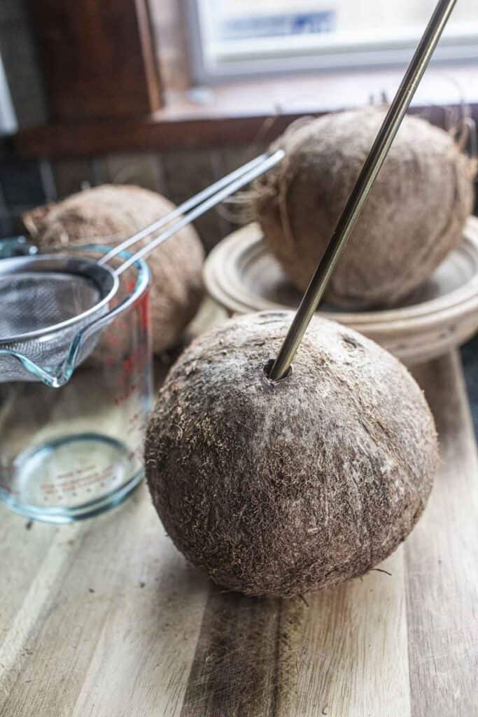 A metal straw inside a coconut. 