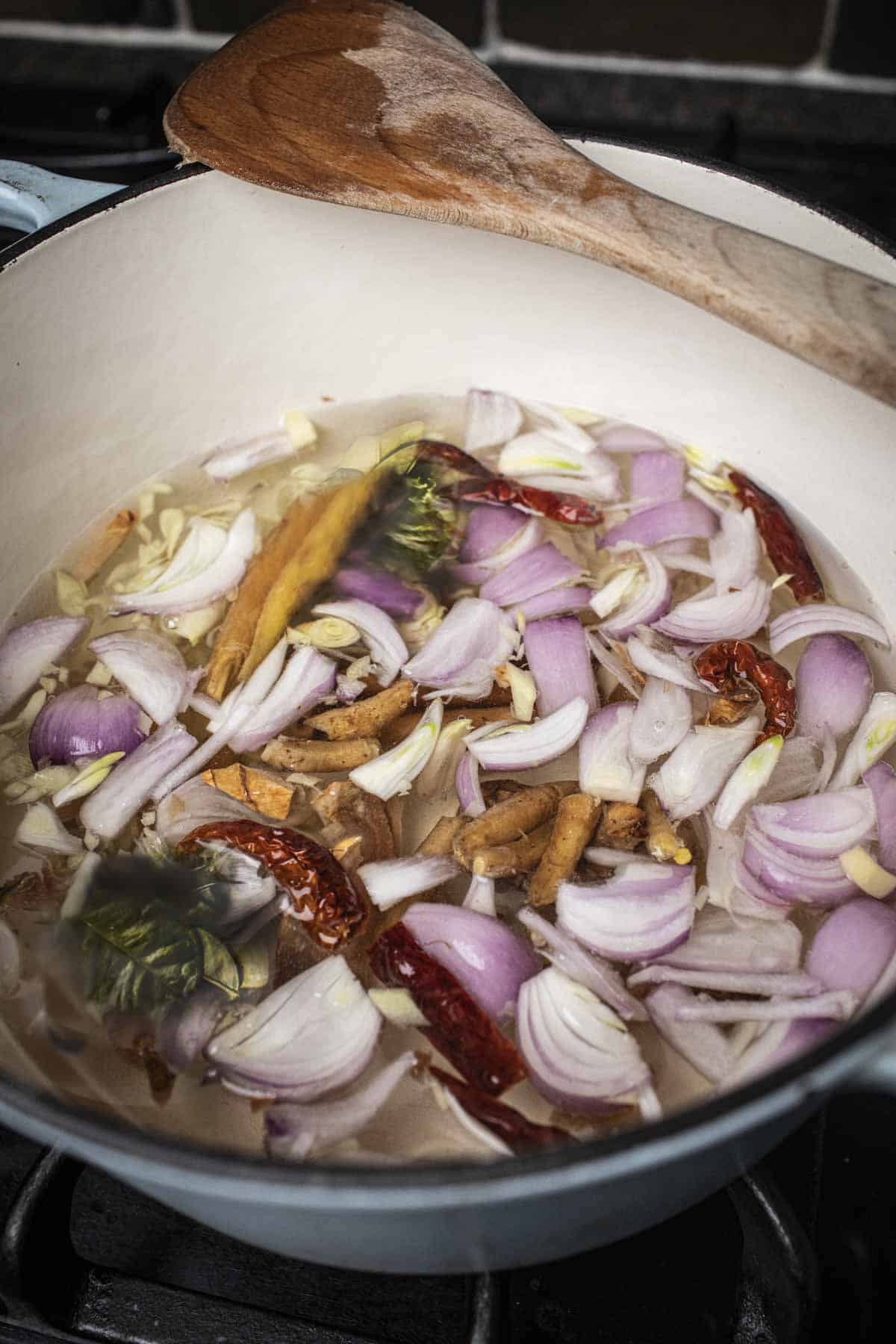 herbs boiling in a pot for Khanom jeen nam ya recipe.
