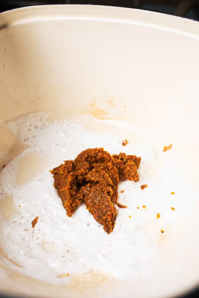 Khao Soi Curry paste and coconut milk in a pot. 