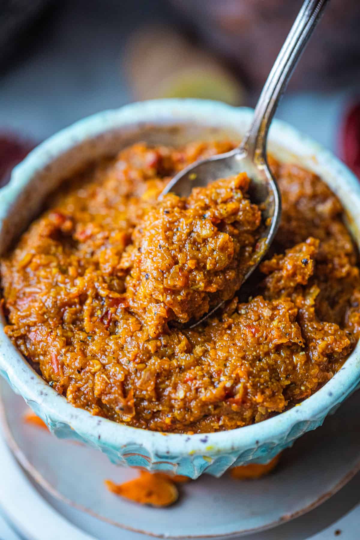 Kao Soi curry paste in a bowl with a spoon in the middle.