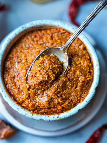 Kao Soi paste in a bowl on the table with a spoon.