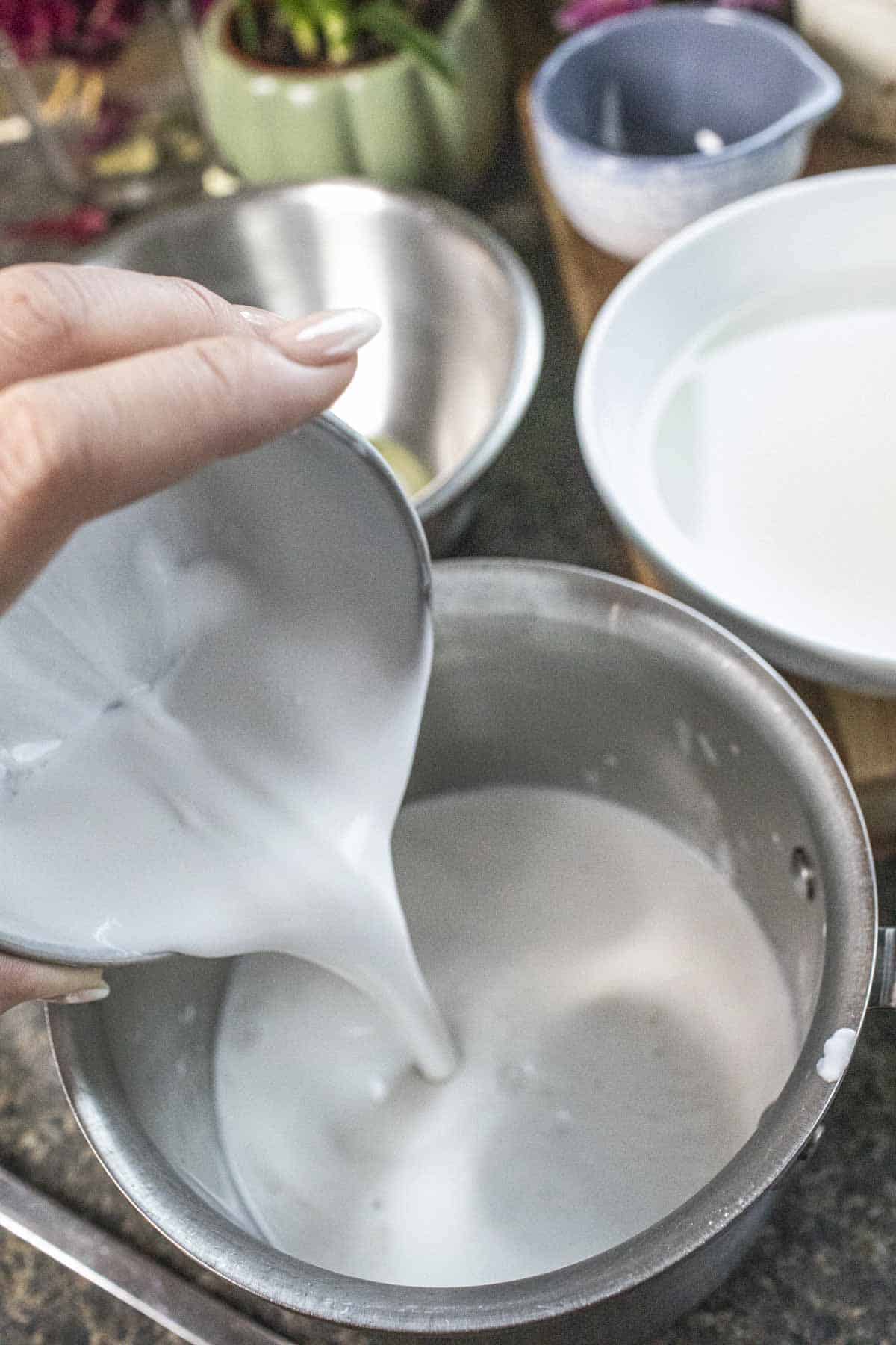 Coconut milk pouring Into a saucepan. 