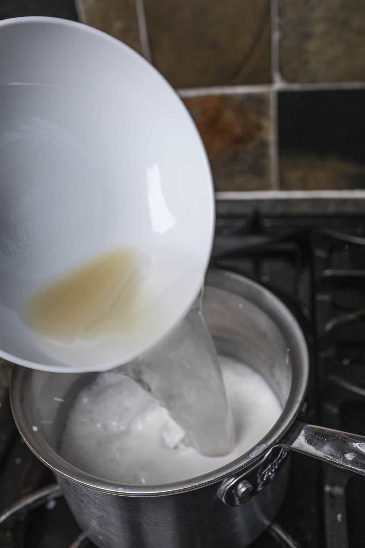 Agar solution pouring into a saucepan with coconut milk.