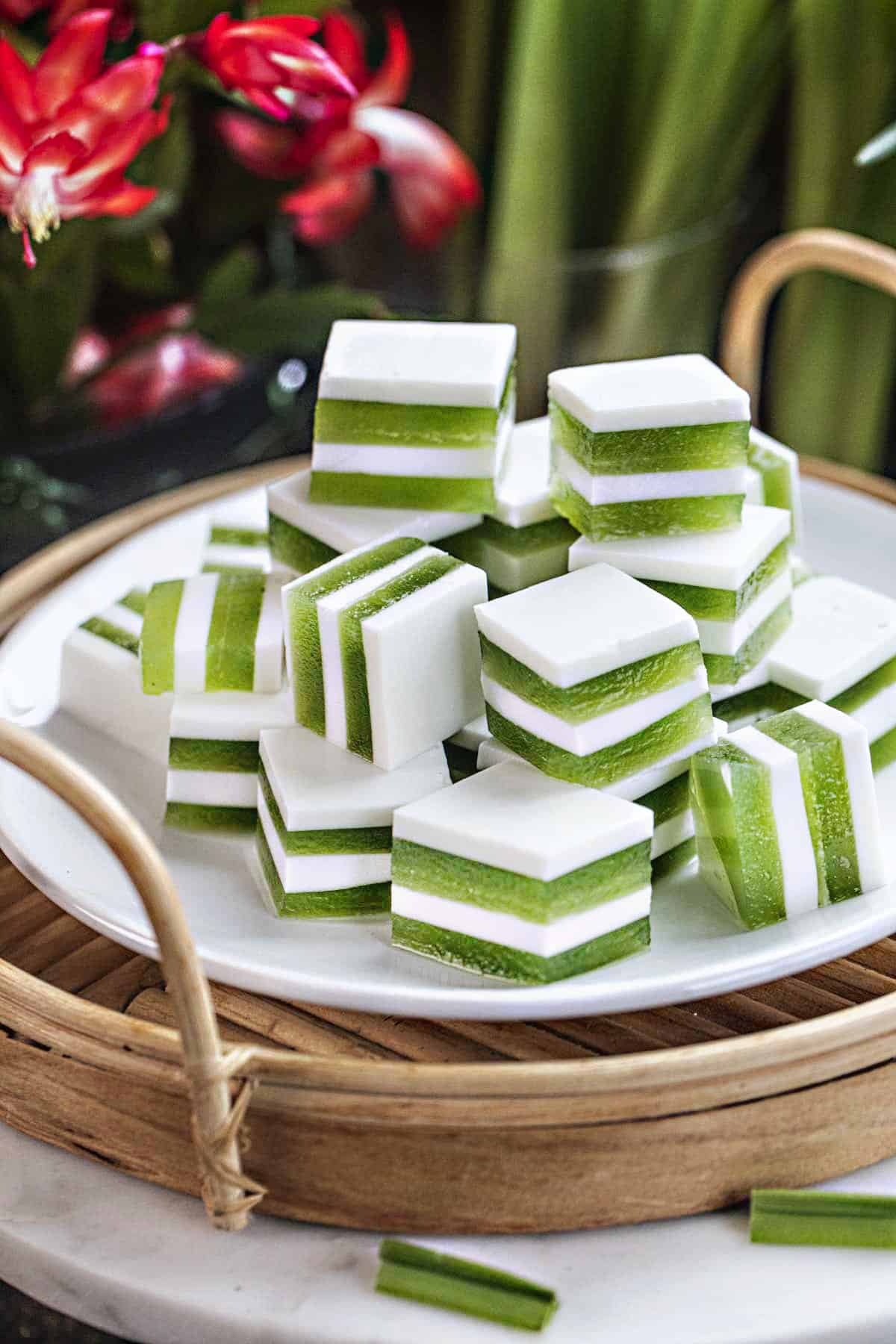 Green and white layered Pandan coconut jelly cubes on a plate. 