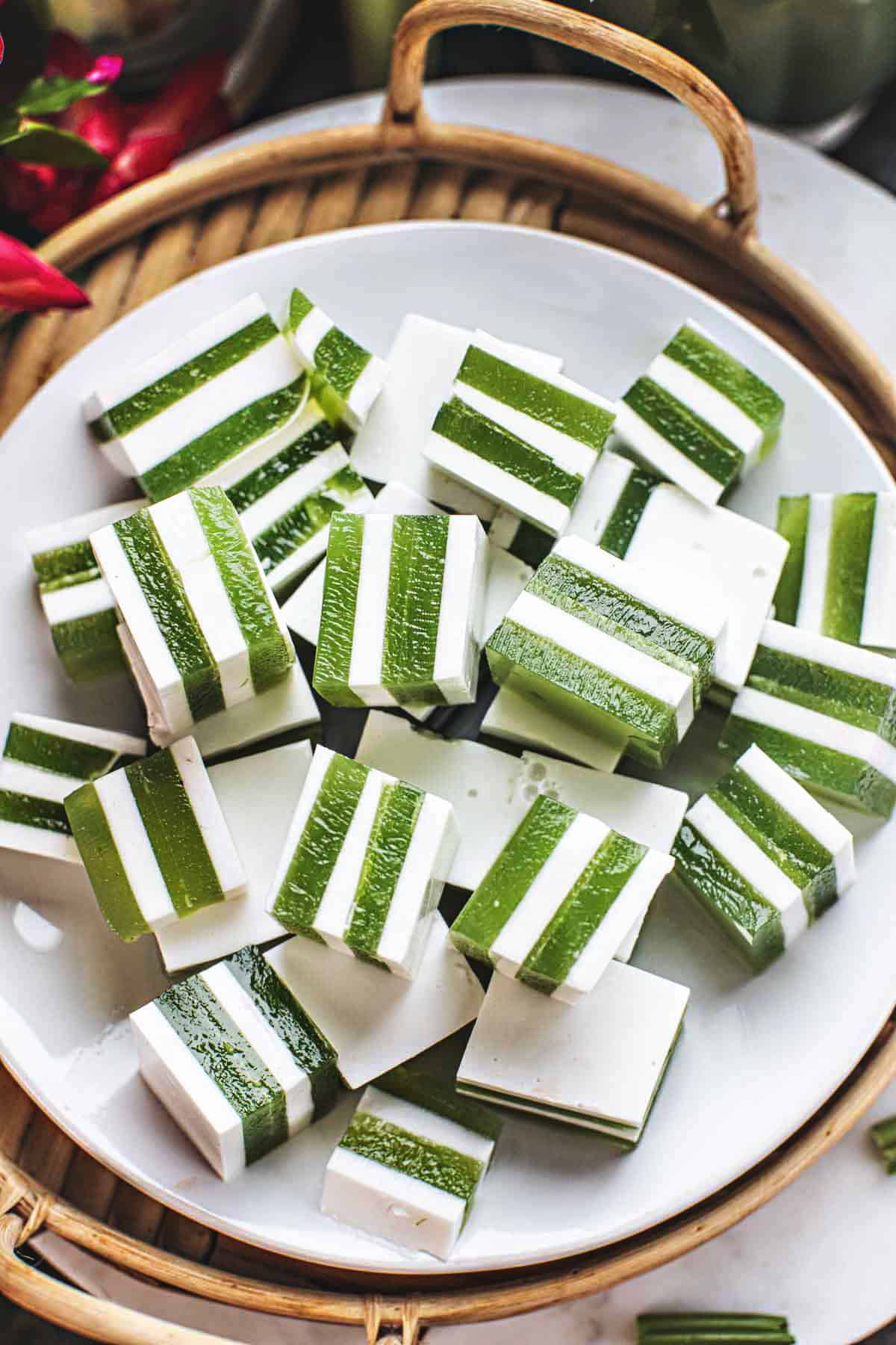 Green and white lawyers of coconut pandan jelly cubes on the table. 