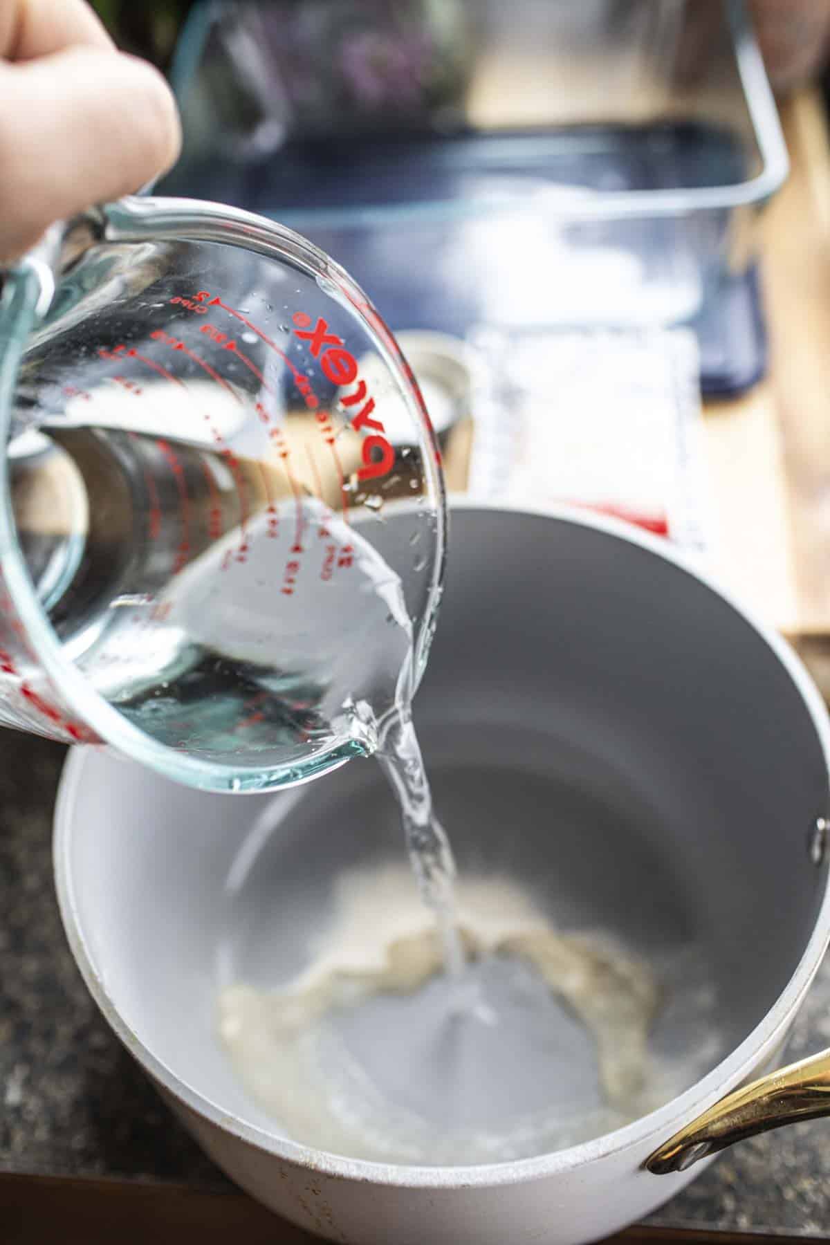 Water pouring into Agar solution in a  a pot. 