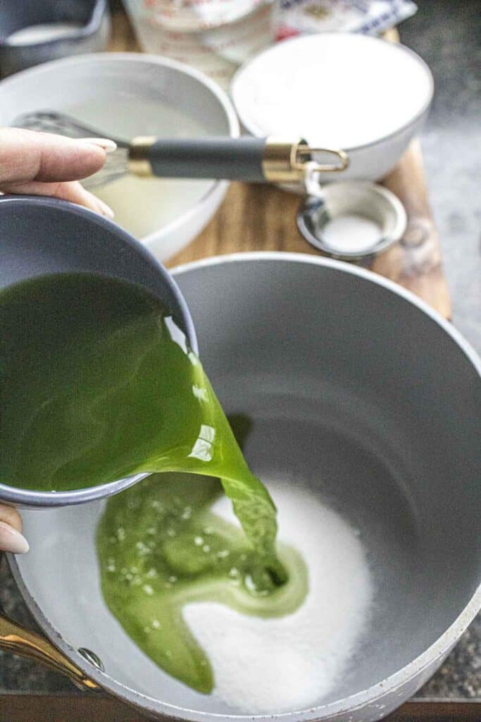 Pandan water pouring  into a sauce pan on the stove. 