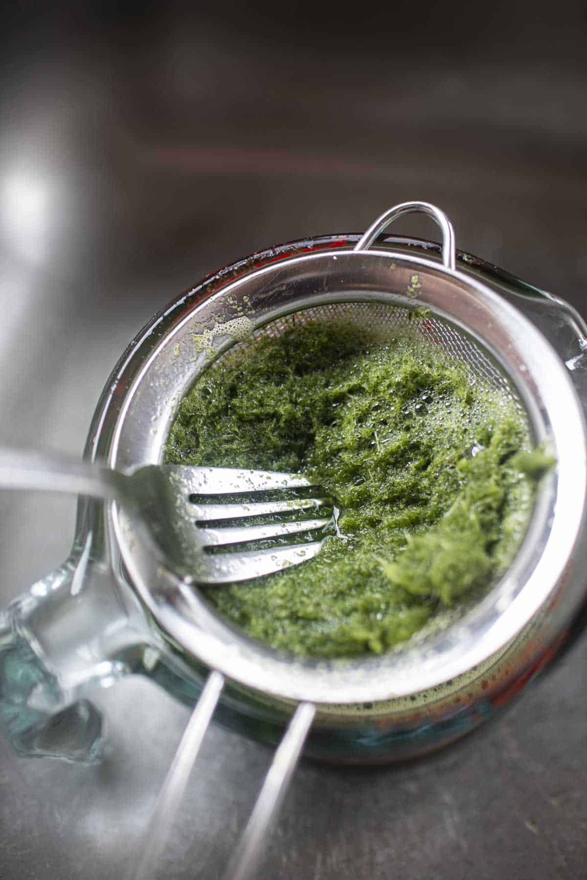 Blended pandan mixture in a strainer.