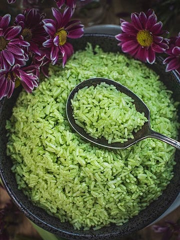 Pandan rice with a spoon in the middle of a bowl.