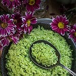 pandan rice in a black bowl with a spoon.