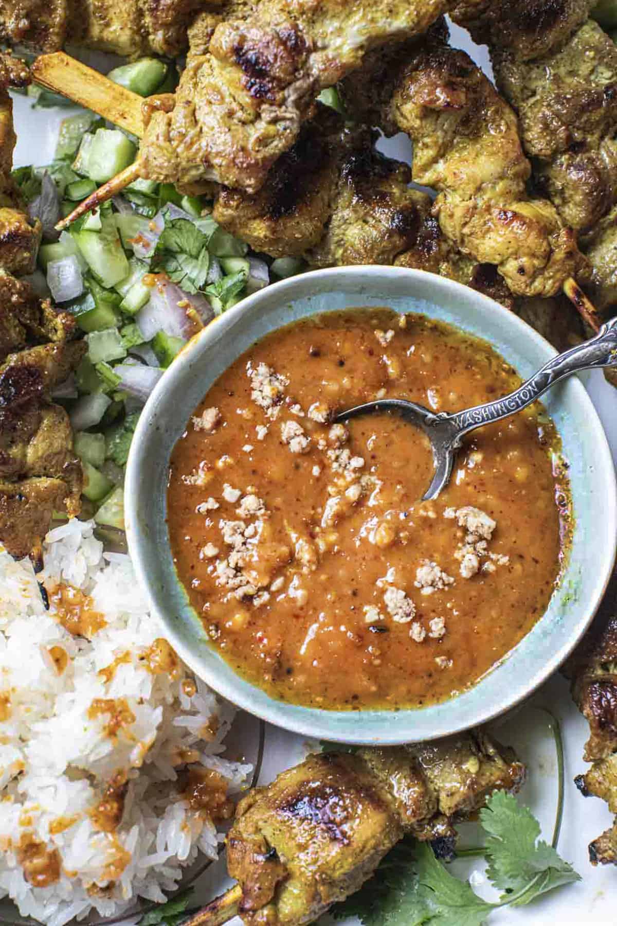 Authentic Thai peanut satay sauce in a bowl with a spoon. 