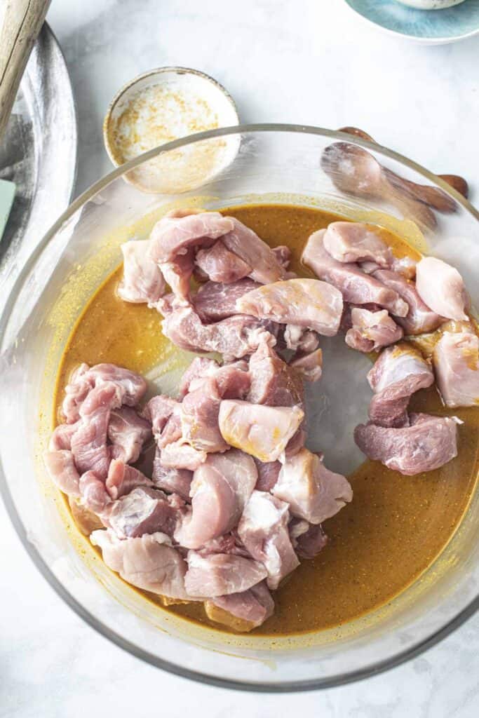 Marinated pork pieces for pork satay in a bowl. 