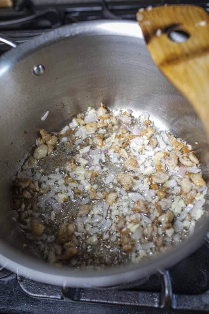 Fried chicken fat, garlic and shallot in pot. 