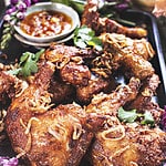 Thai fried chicken Hat Yai on a tray with dipping sauce.