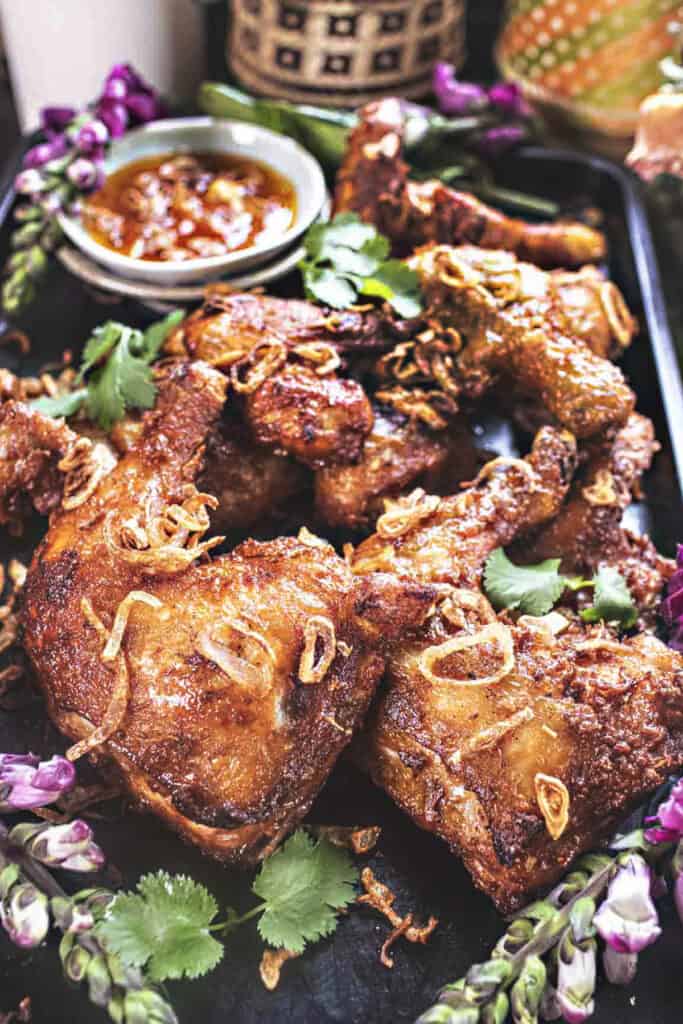 Thai fried chicken Hat Yai on a tray with dipping sauce.