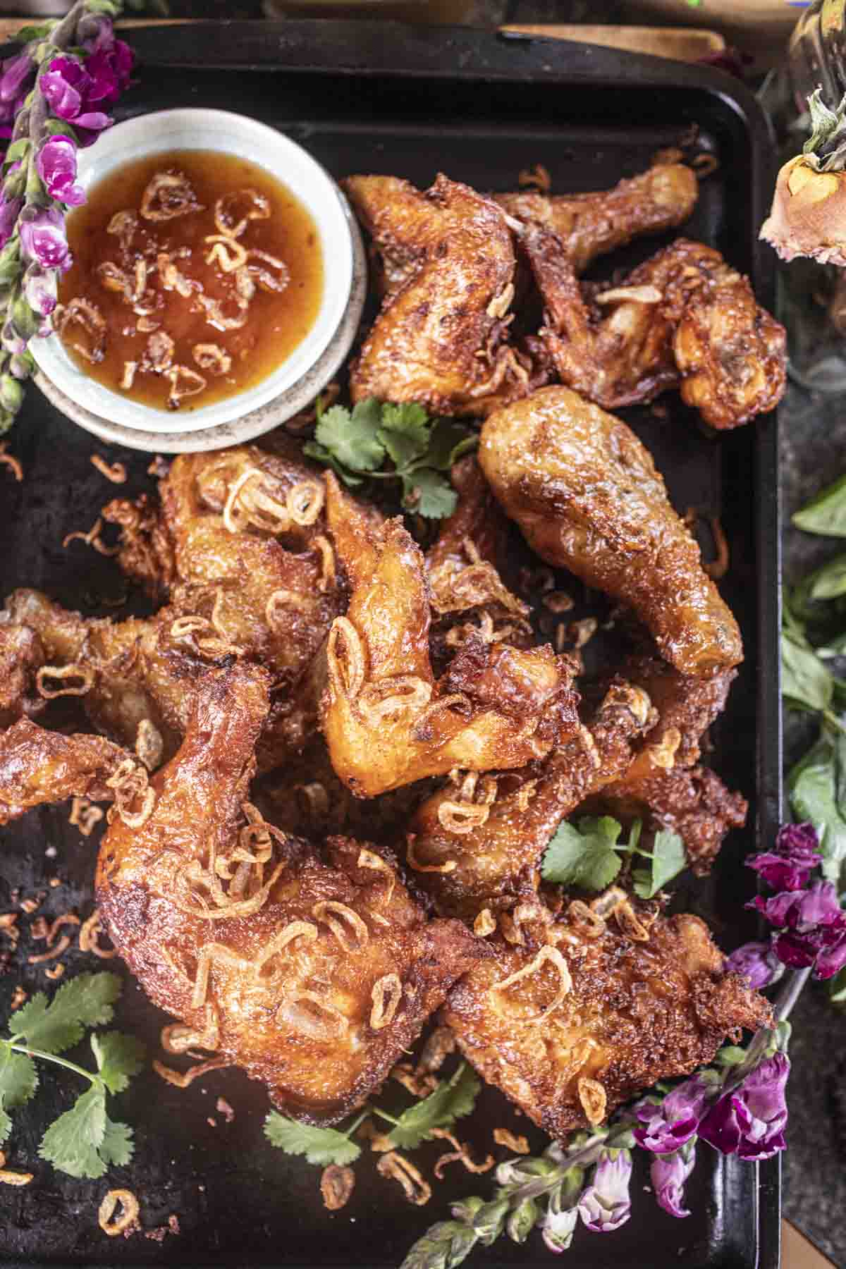 Fried chicken ona tray with flowers garnish.