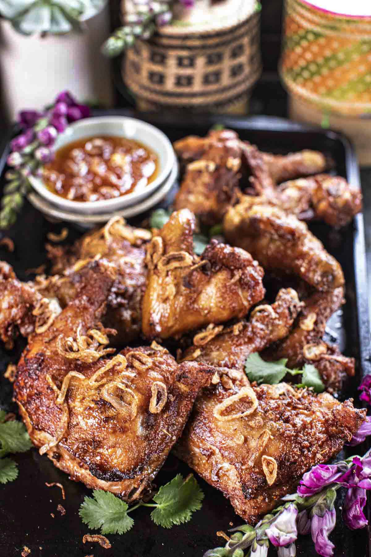 Fried Hai Yai Chicken pieces on a tray with dipping sauce.