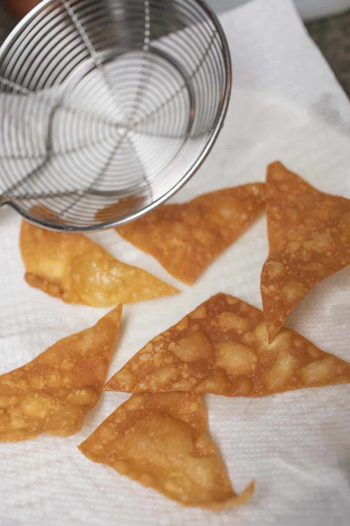 Crispy fried wonton skins on a paper towel. 