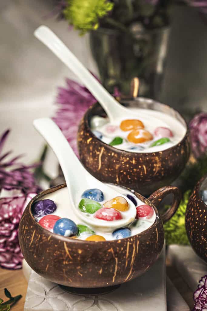 Thai glutinous rice balls dessert in coconut bowls with spoons. 