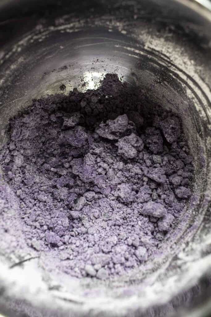 Purple dough clumps in a bowl. 