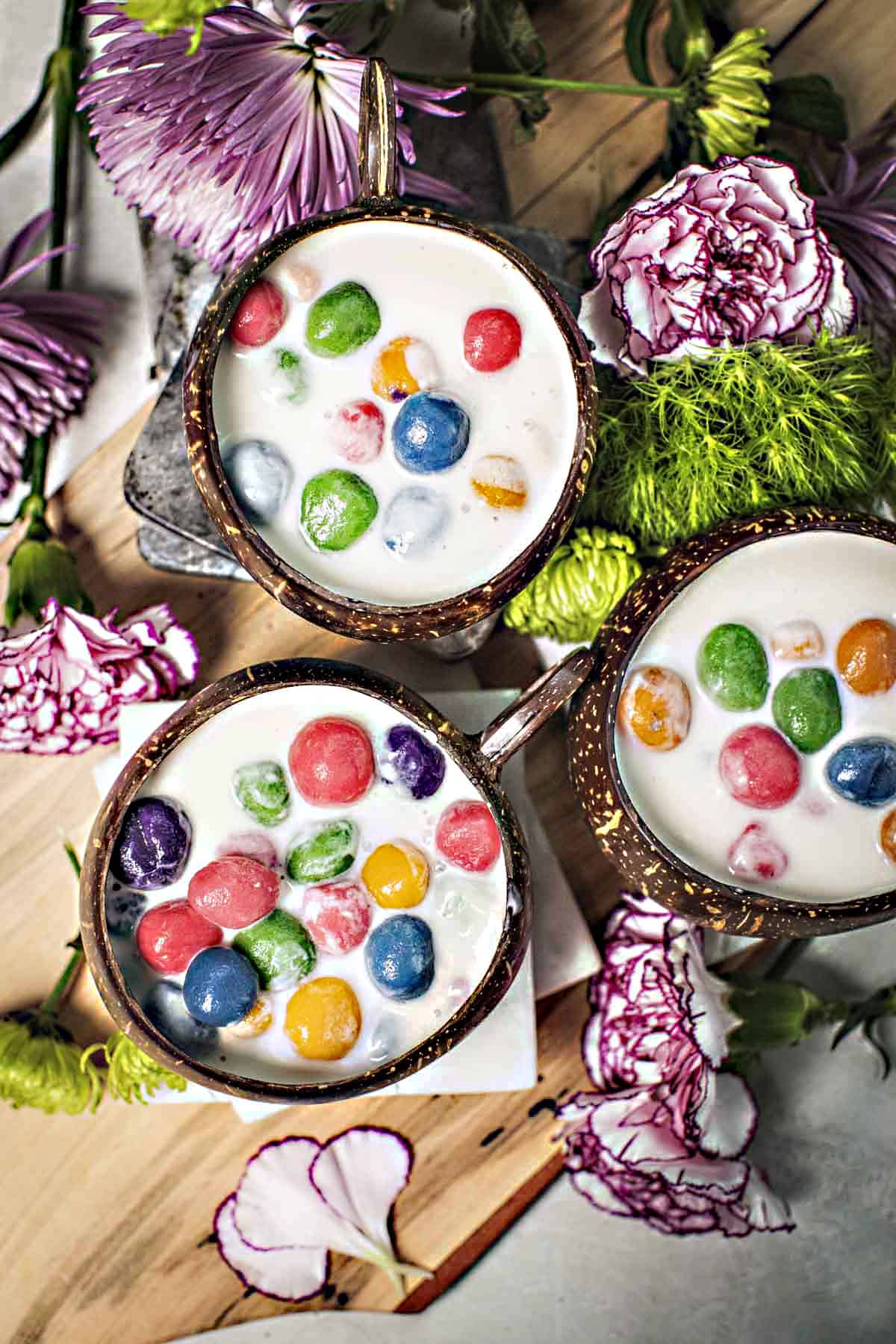 Thai glutinous rice balls dessert in 3 coconut bowls.