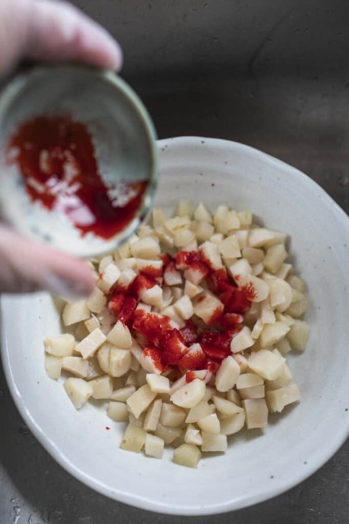 Red food coloring in a bowl with diced waterchesnuts.