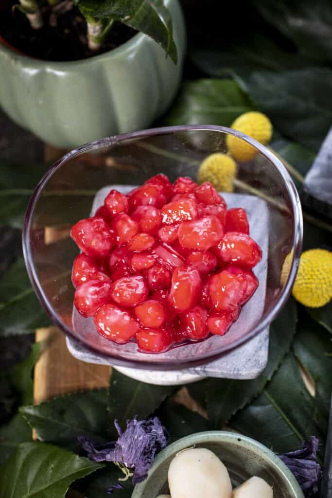 Thai red rubies dessert in a clear bowl.