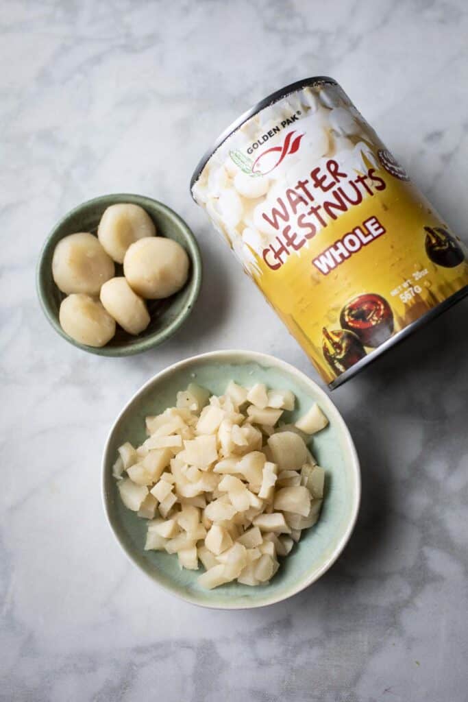 Canned, whole and diced water chesnuts on the table. 