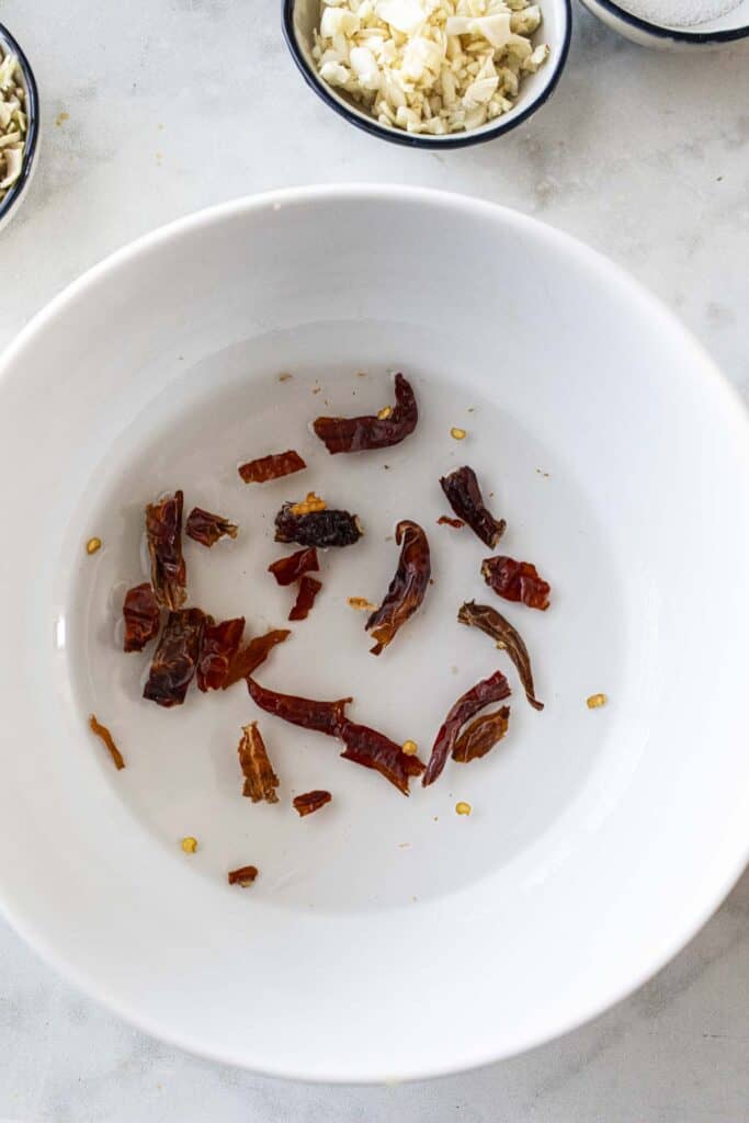 Dried chilis in a bowl of water. 