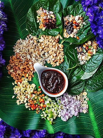 Miang Kham ingredients and sauce on a platter.