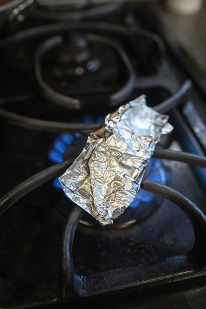 Aluminum foil roasting over a stove top.