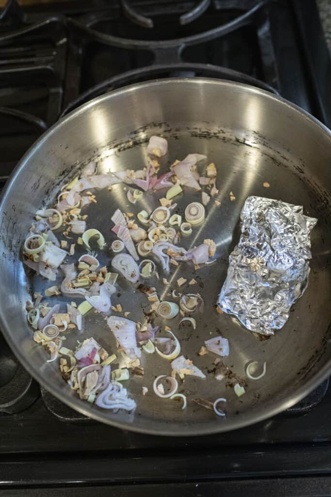 Roasting aromatics and Aluminum foil over a stove top.