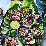 Nam Sod lettuce wraps on a tray with peanuts in the middle.