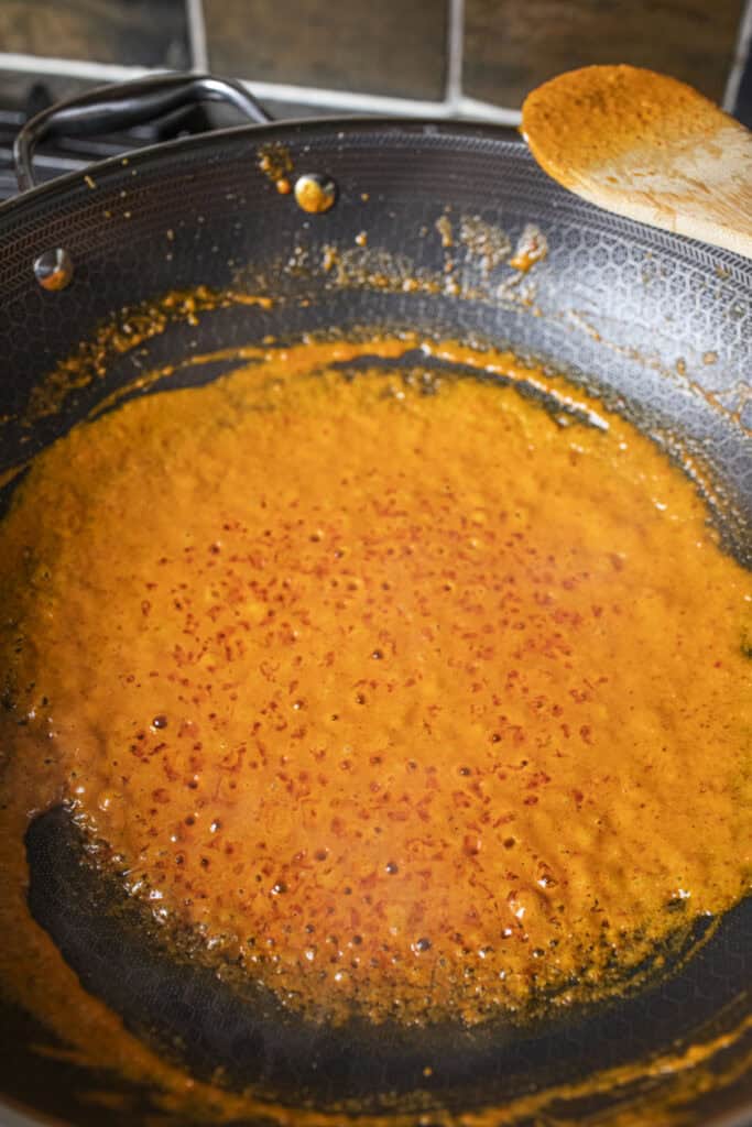 Coconut milk in orange curry sauce. 