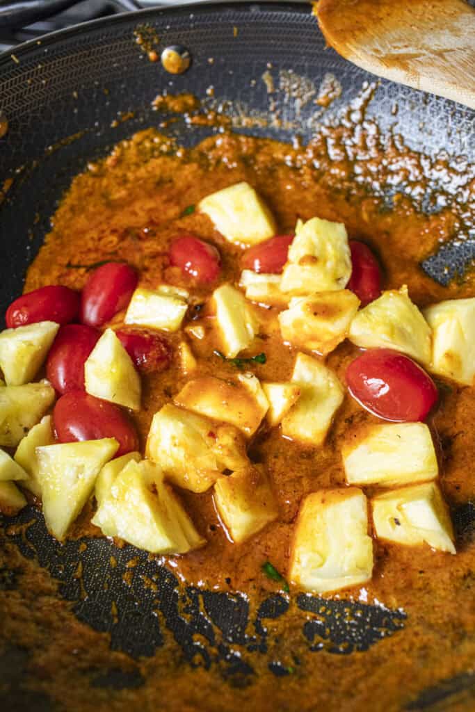 Pineapple and tomatoes in red curry sauce. 