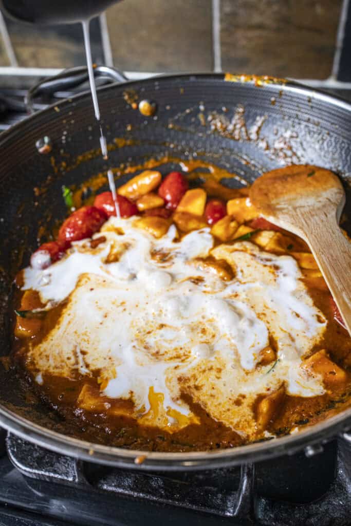 Coconut milk in a red curry sauce.