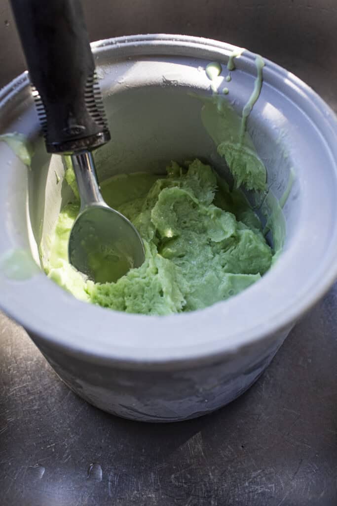 Green ice cream in an ice cream bowl machine. 