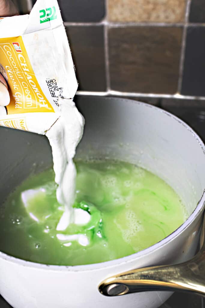 coconut milk is added to a sauce pan with green coloring.