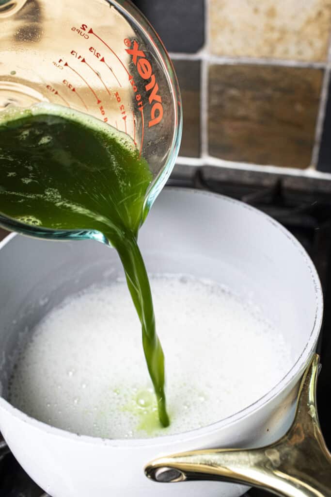 pandan juice is poured into coconut milk.