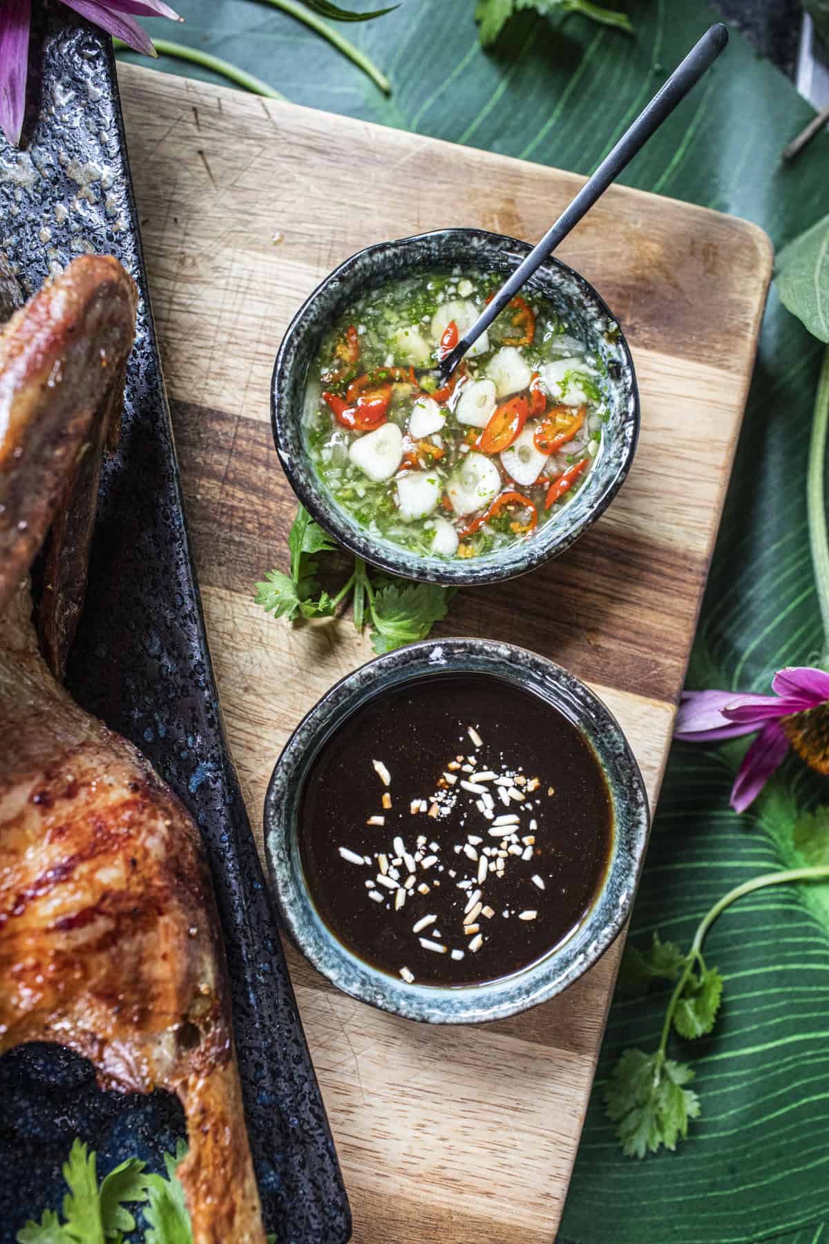 Dipping sauces for roasted duck on a cutting board. 