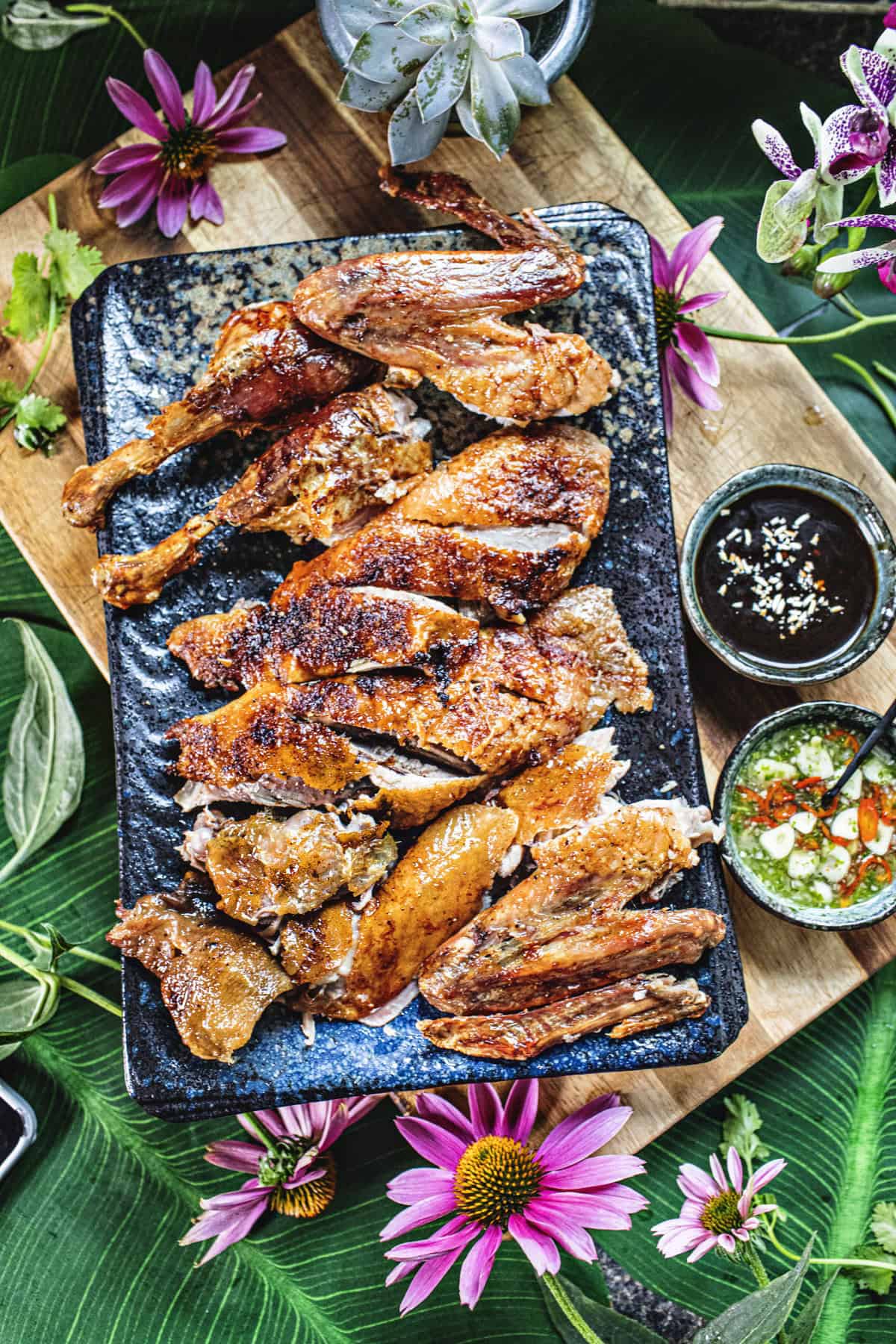 Roasted duck slices on a platter on a cutting board. 