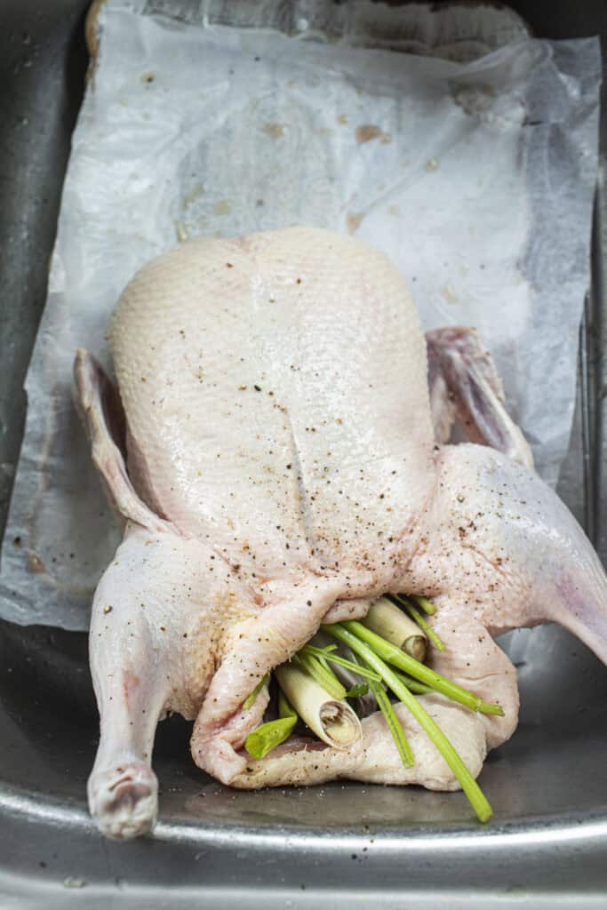 Whole duck in a sink stuffed with herbs. 