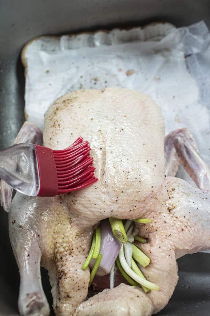 Whole duck stuffed with herbs and brushed with oil.