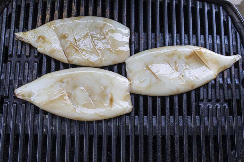 3 squid on a grill.