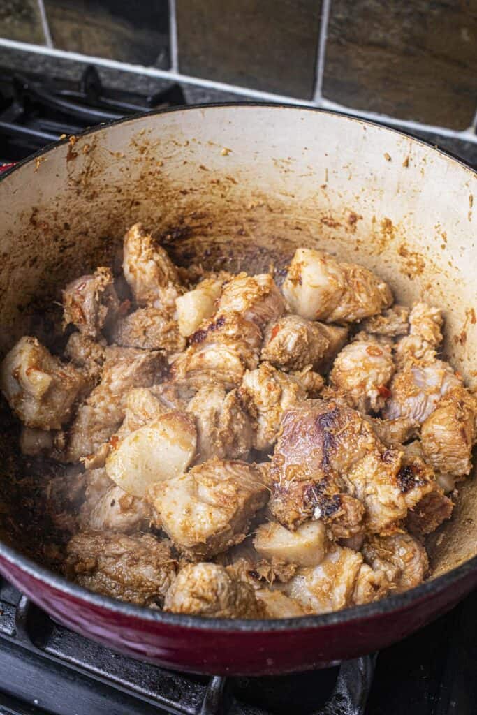 Pork chunks with hung lay paste in a dutch oven.