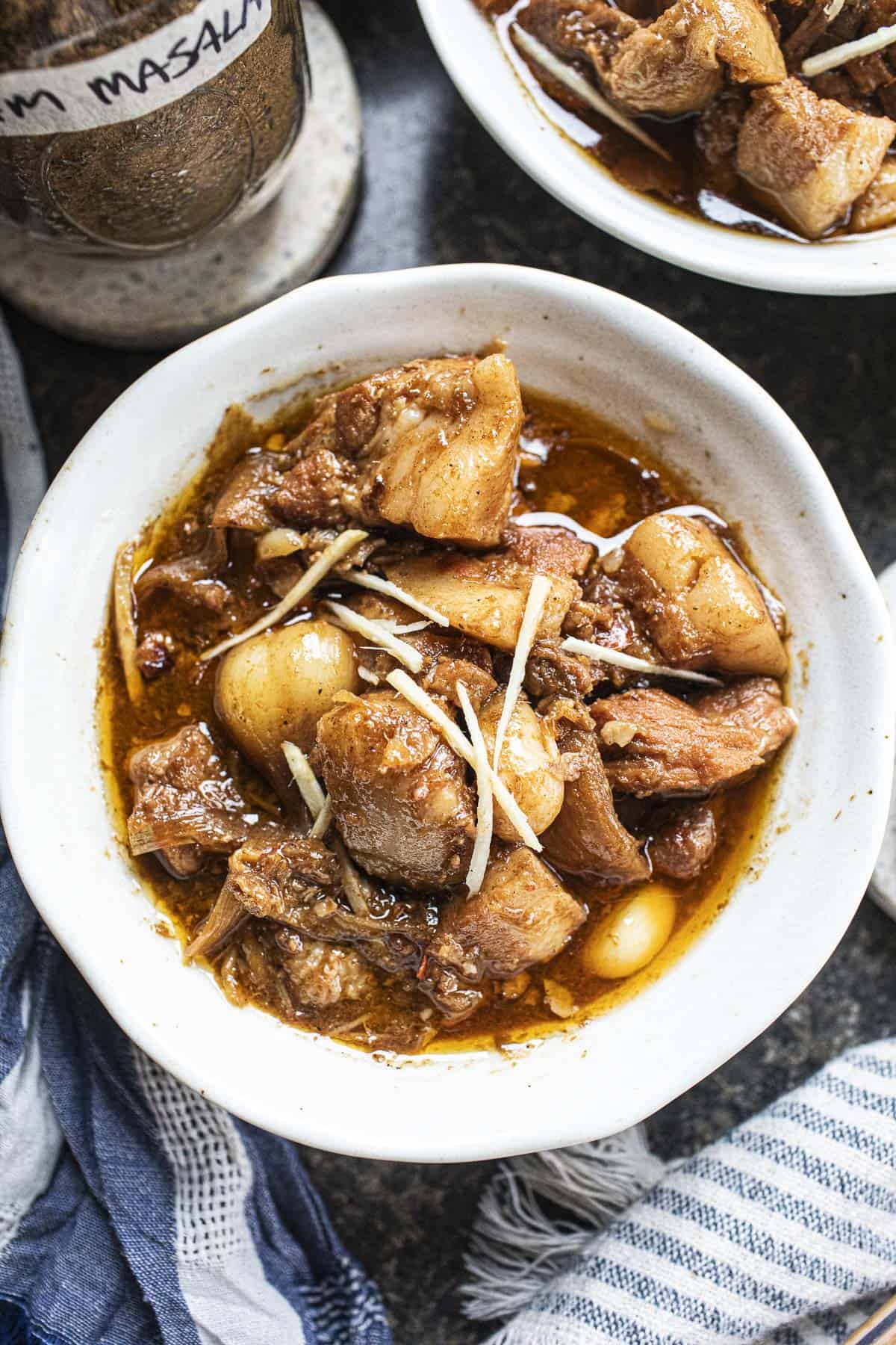 Hang Lay pork curry in a bowl with ginger slices. 