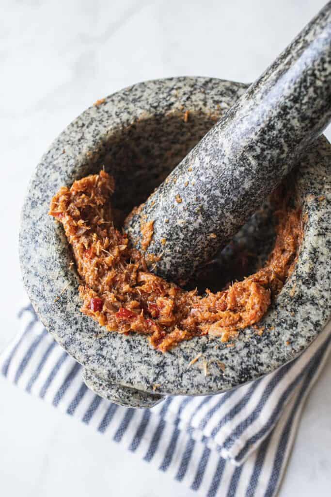 Curry paste in a mortar with pestle.