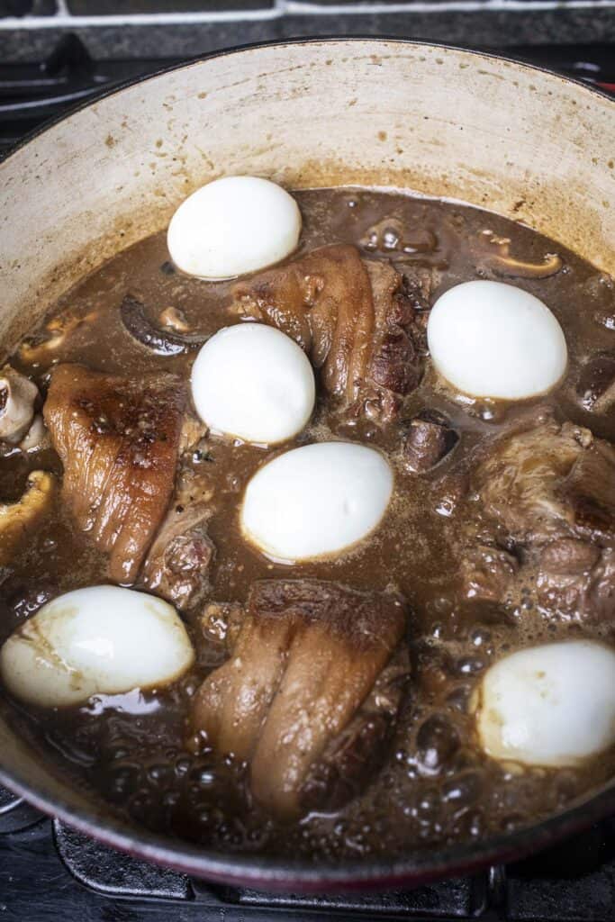 7 Eggs in pork hock stew in a pot.