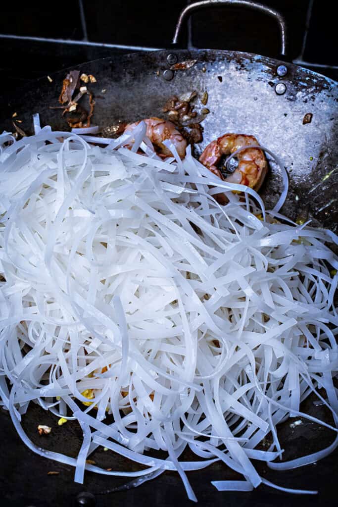 Rice noodles for pad thai in a wok. 
